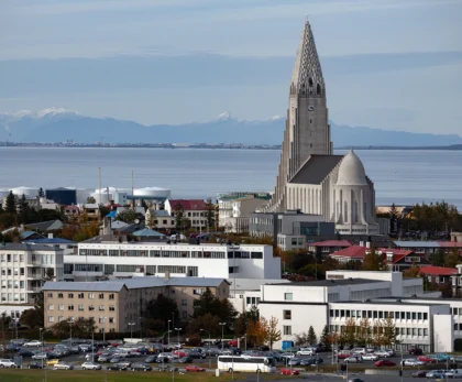 Hallgrímskirkja en Reikiavik con la bahía y montañas al fondo, vista urbana panorámica