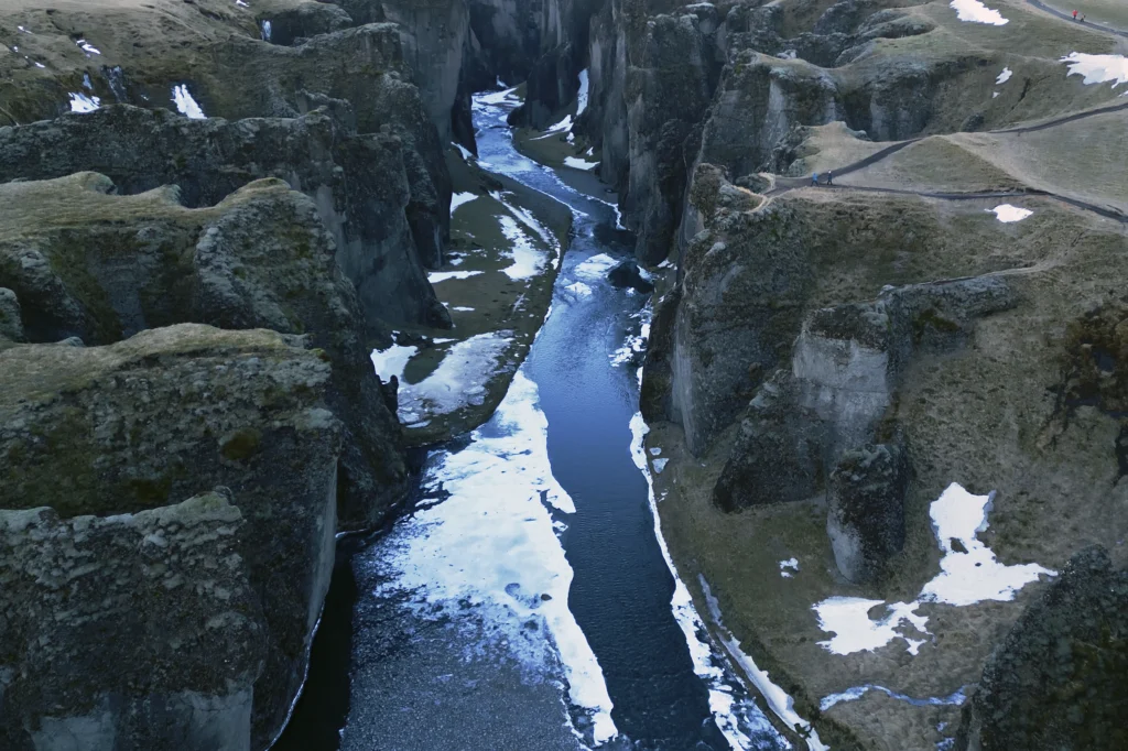 Cañón Fjaðrárgljúfur en Islandia con río y restos de nieve entre acantilados