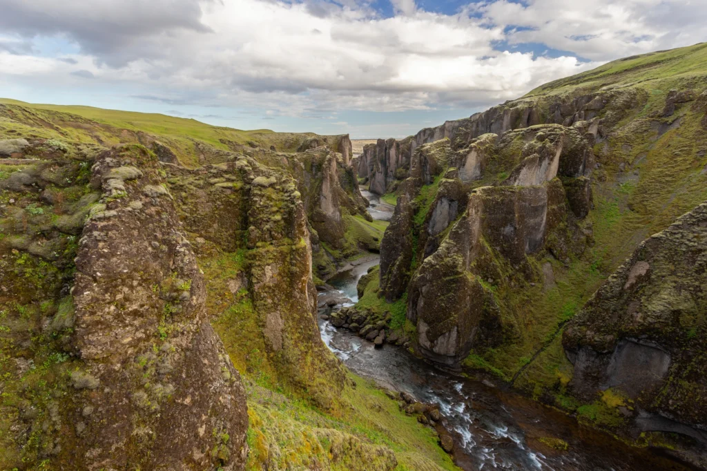 Cañón Fjaðrárgljúfur en Islandia con río entre acantilados cubiertos de musgo
