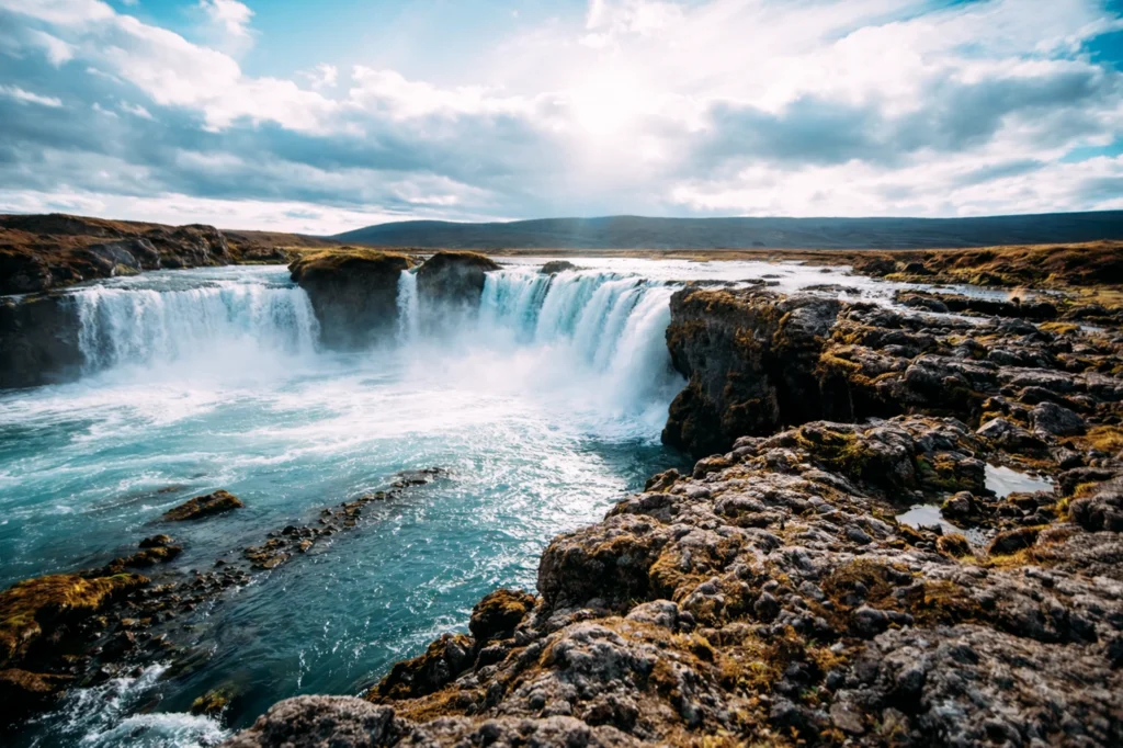 Cascada Goðafoss en Islandia con agua turquesa y paisaje volcánico