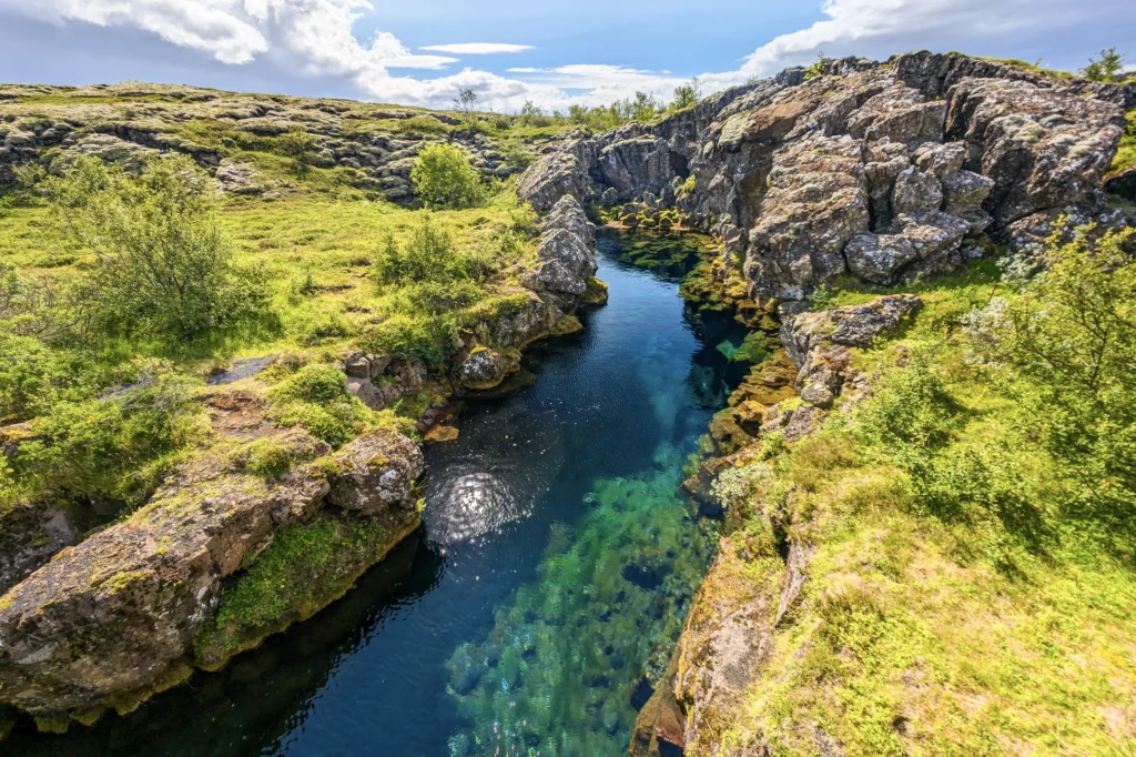 Fisura de Almannagjá en el Parque Nacional Thingvellir con agua cristalina entre placas tectónicas en Islandia.
