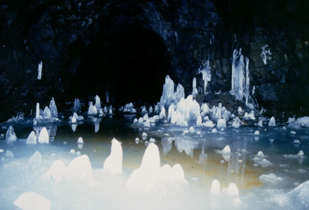 Formaciones de hielo dentro de la cueva de lava Surtshellir con estalactitas y suelo helado en Islandia.