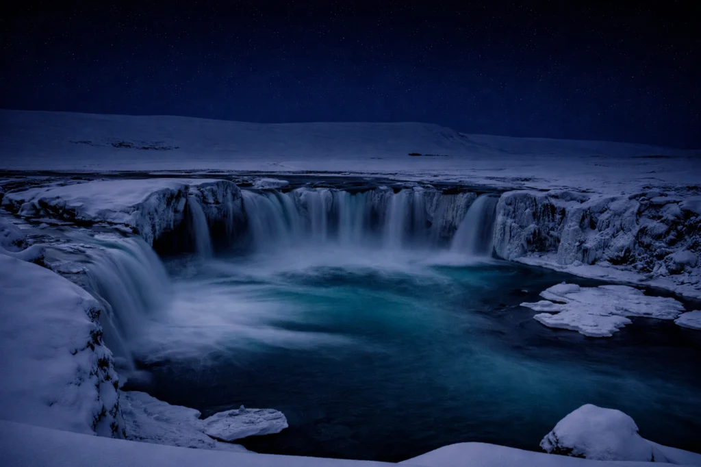Cascada Goðafoss de noche con cielo estrellado en Islandia