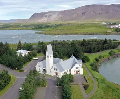 Iglesia de Selfoss junto al río Ölfusá con paisaje natural y montañas al fondo en la ciudad de Selfoss, Islandia.