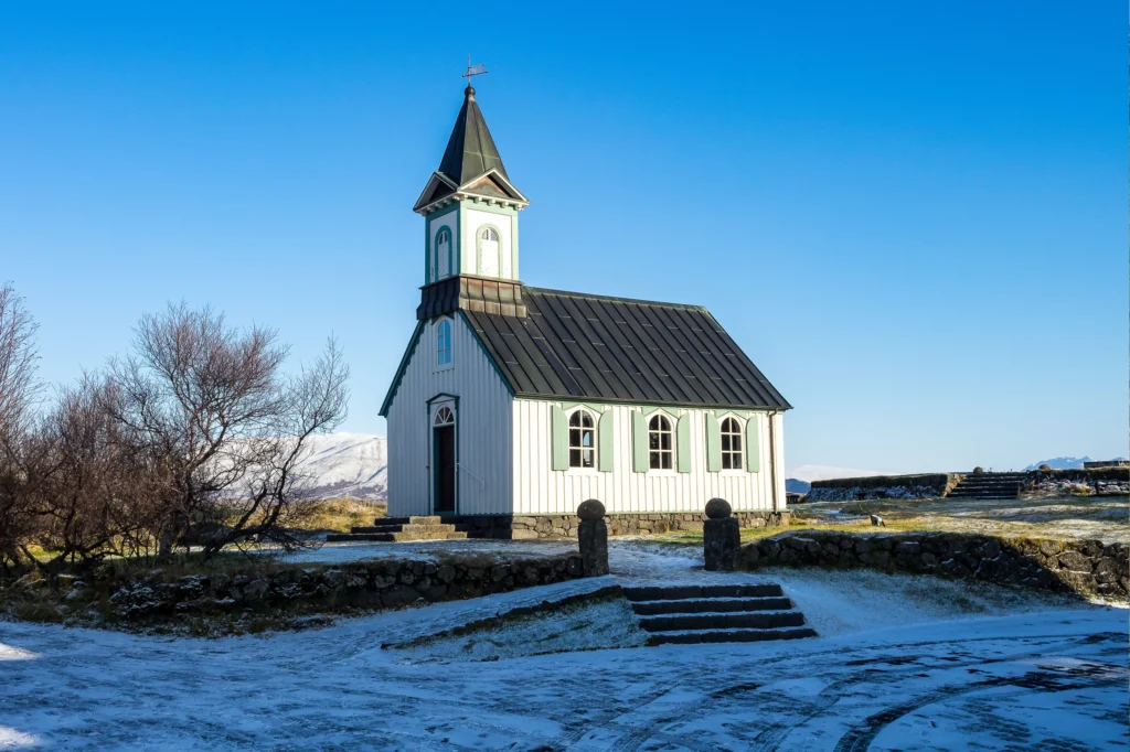 Iglesia Þingvallakirkja en el Parque Nacional Thingvellir rodeada de paisaje volcánico en Islandia.