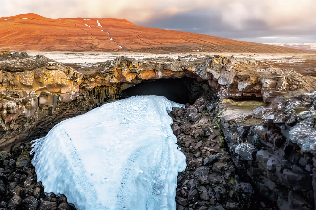 Interior de la cueva de lava Surtshellir con hielo y formaciones volcánicas en Islandia.