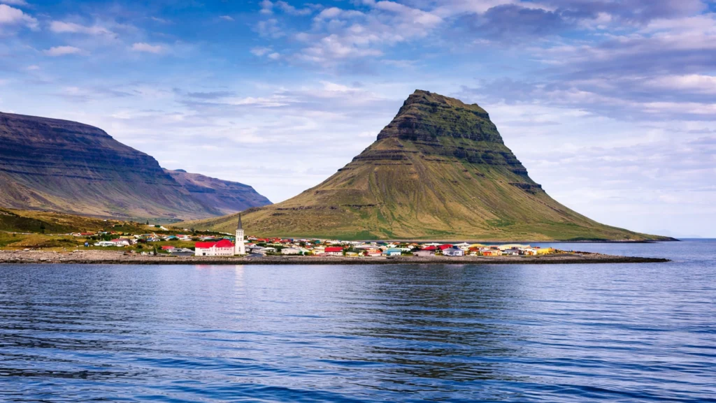 Kirkjufell visto desde el mar con el pueblo de Grundarfjörður en Islandia.