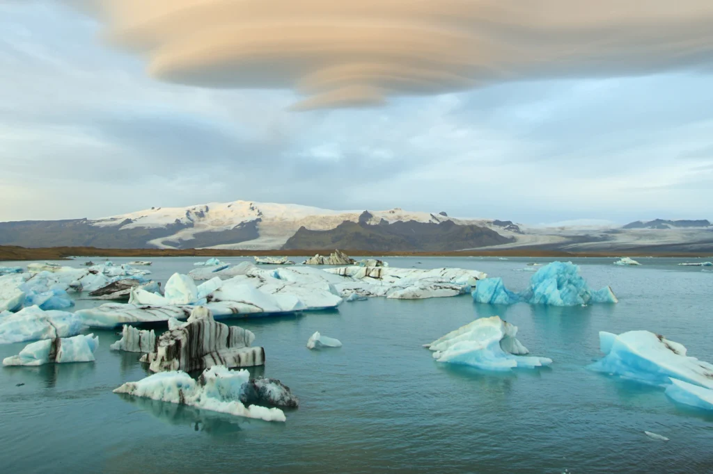 Icebergs flotando en la laguna glaciar Jökulsárlón con montañas nevadas al fondo en Islandia