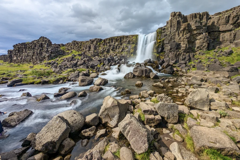Salto de agua de Öxarárfoss cayendo sobre rocas volcánicas en el Parque Nacional Thingvellir, Islandia.