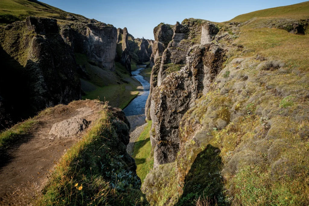 Cañón Fjaðrárgljúfur con sendero y río entre acantilados en Islandia