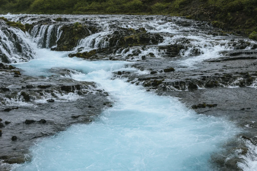 Cascada Bruarfoss con aguas turquesas y formaciones rocosas en Islandia