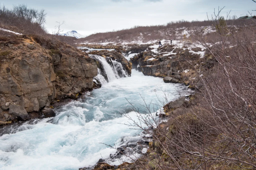 Cascada Bruarfoss con río azul y paisaje invernal en Islandia
