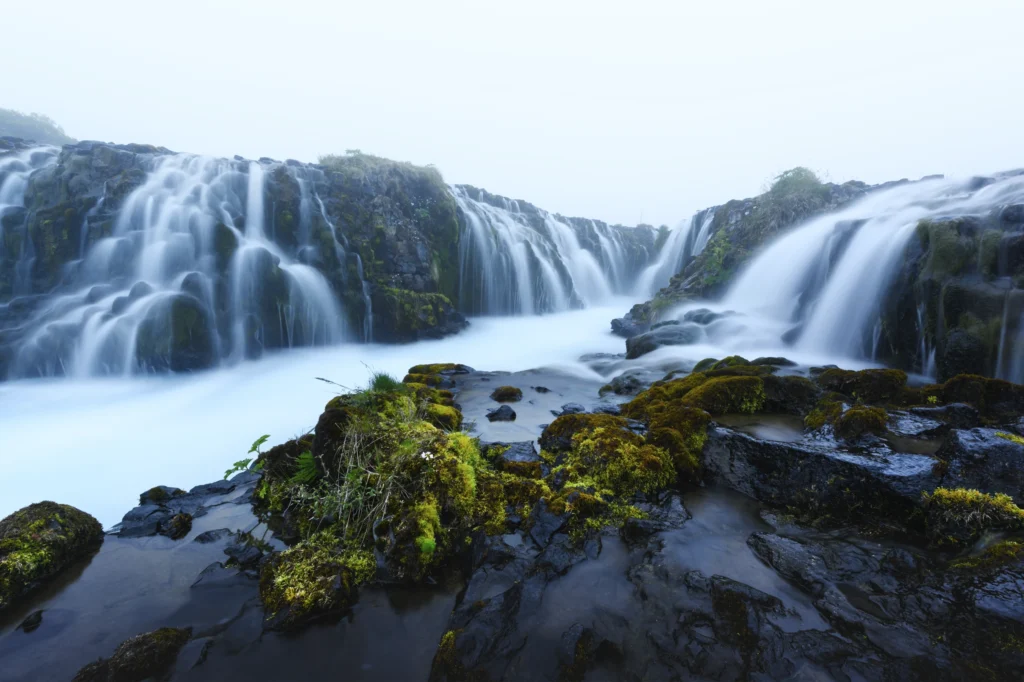 Cascada Bruarfoss con múltiples saltos de agua y rocas cubiertas de musgo en Islandia