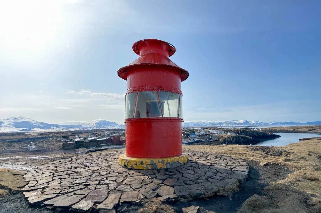 Faro rojo de Stykkishólmur con vistas al pueblo y paisaje costero en Islandia
