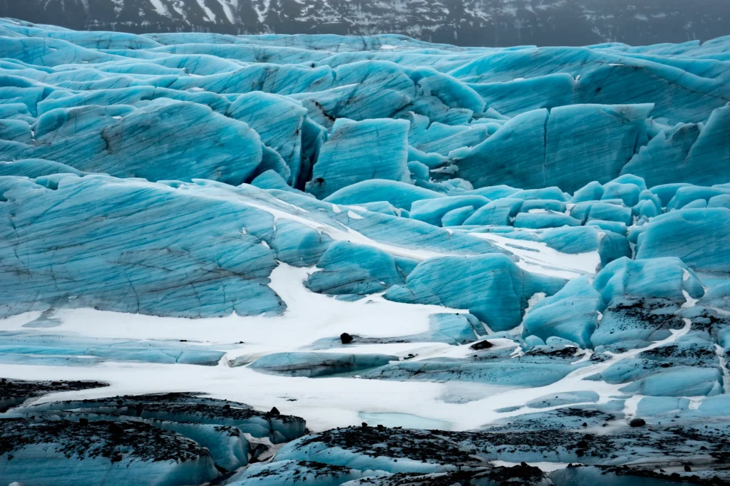 Formaciones de hielo azul del glaciar Vatnajökull con grietas y capas compactadas en Islandia