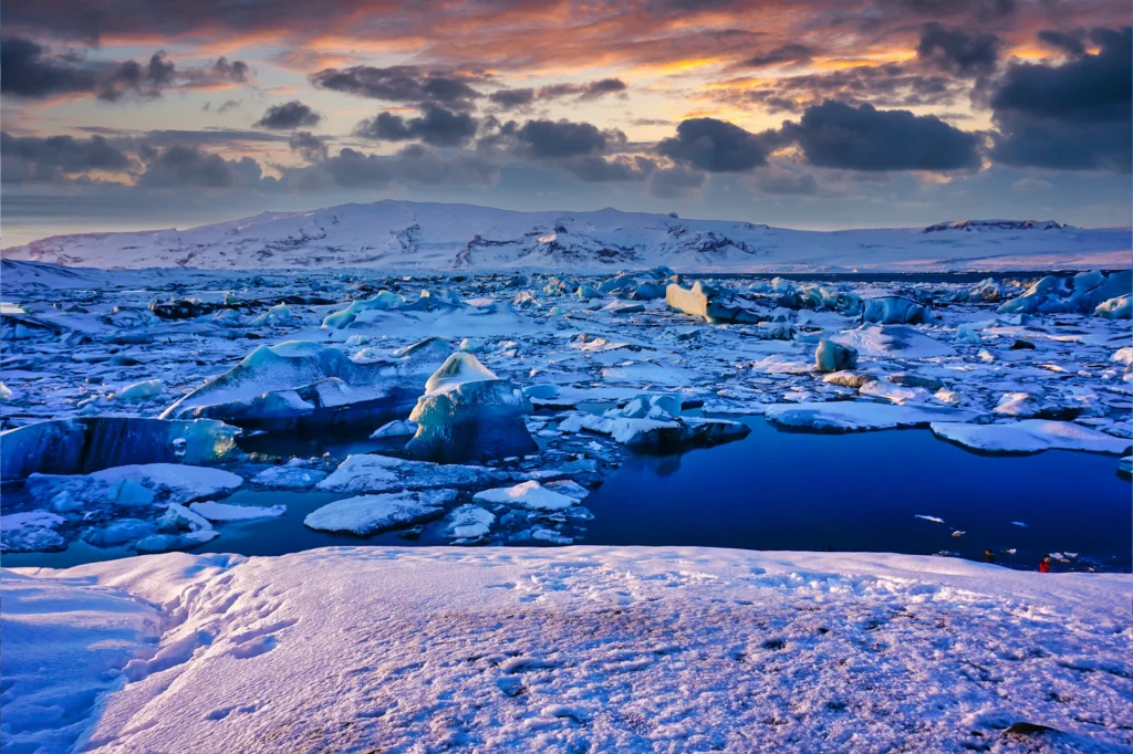 Laguna glaciar Jökulsárlón congelada con icebergs al atardecer en Islandia
