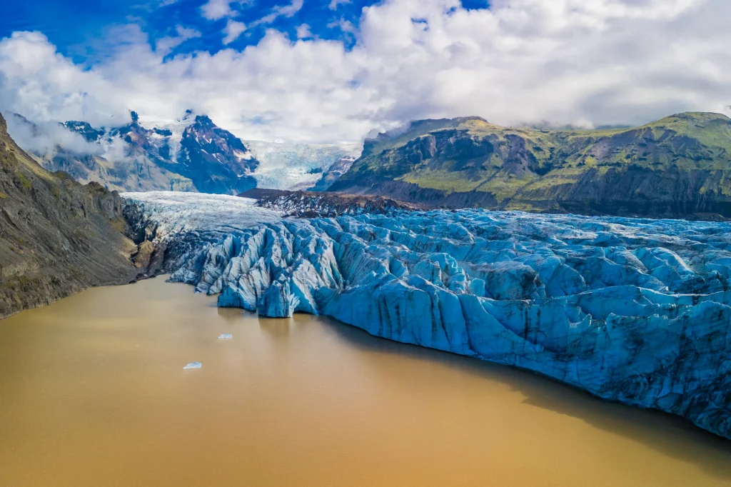 Lengua glaciar de Vatnajökull con laguna de agua turbia y montañas en Islandia