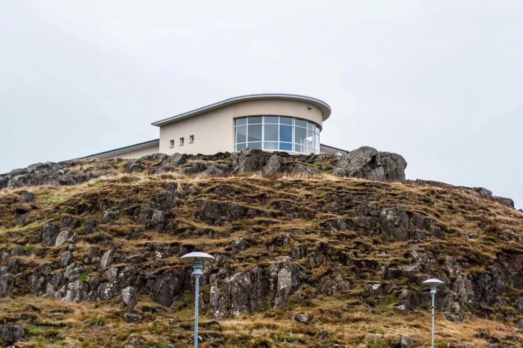Library of Water en Stykkishólmur, edificio moderno sobre colina rocosa en Islandia