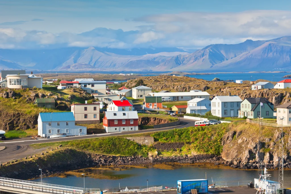 Vista panorámica de Stykkishólmur con casas de colores y montañas al fondo en Islandia