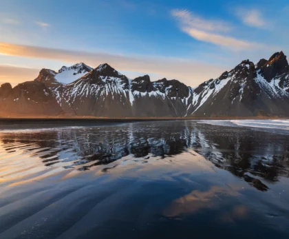 Montañas de Vestrahorn en Stokksnes reflejadas en la playa de arena negra