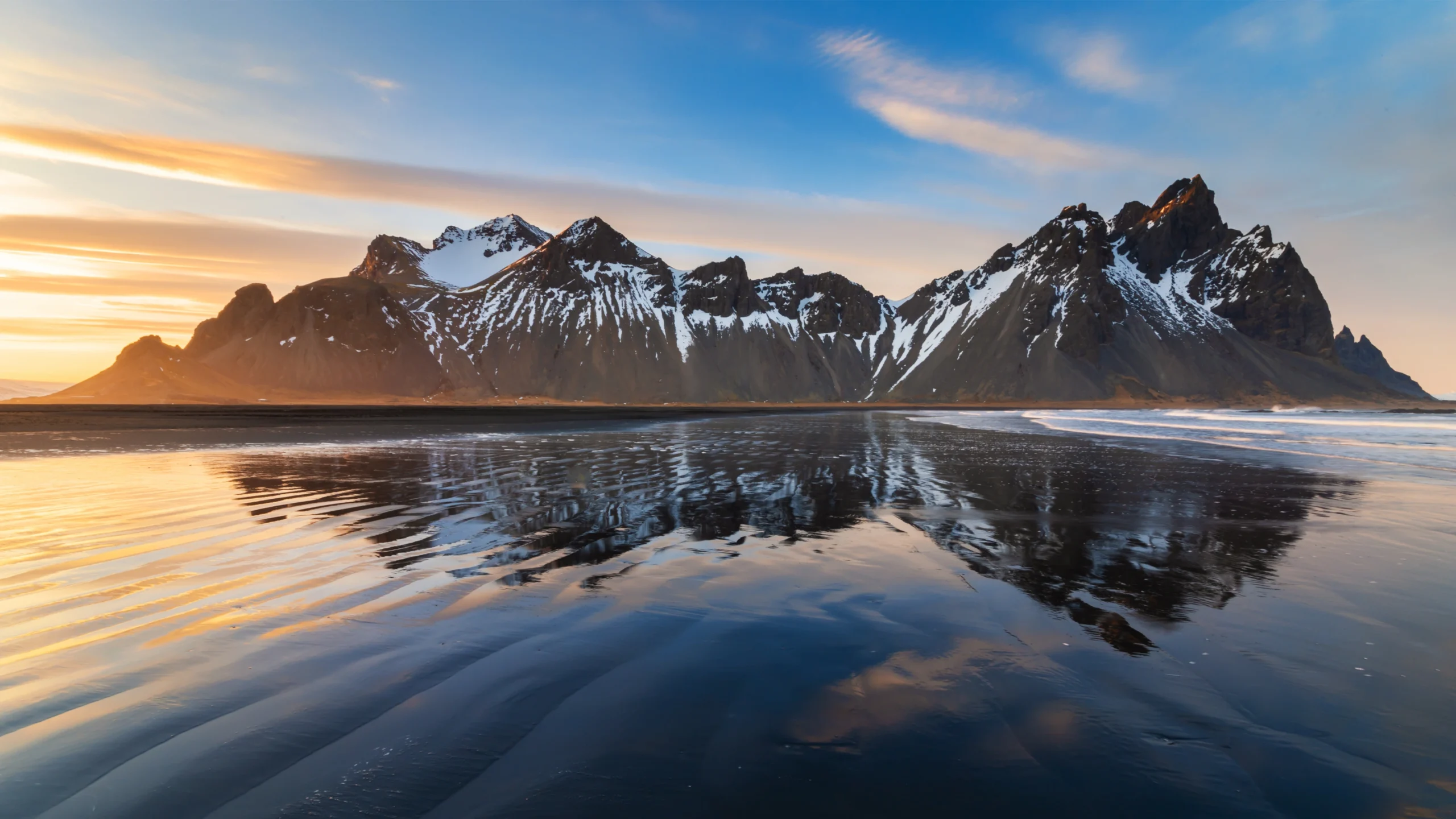Montañas de Vestrahorn en Stokksnes reflejadas en la playa de arena negra