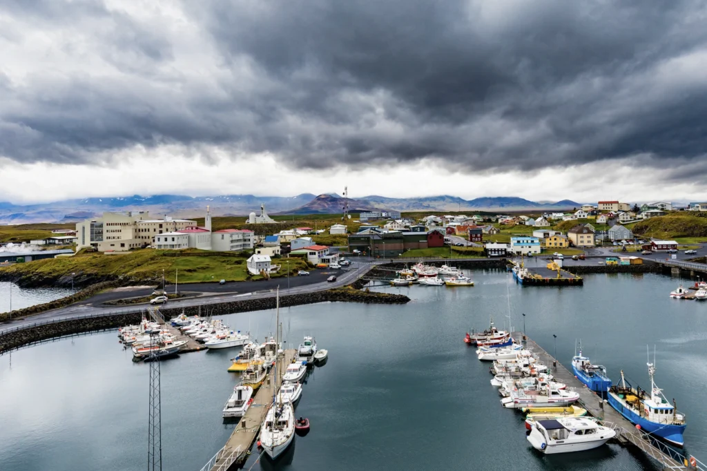 Puerto de Stykkishólmur con barcos y cielo nublado dramático en Islandia