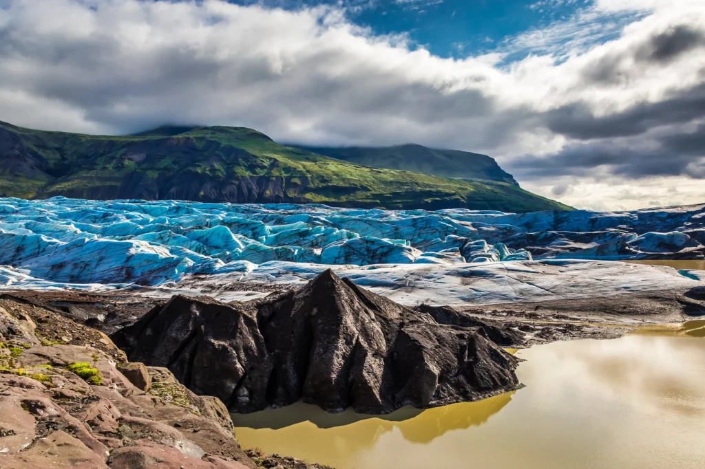 Glaciar Vatnajökull con hielo azul, roca volcánica y laguna glaciar en Islandia