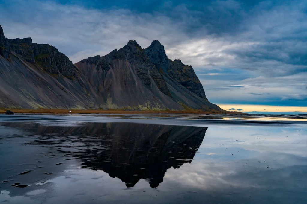 Vestrahorn reflejado en la playa de arena negra de Stokksnes con cielo nublado en Islandia