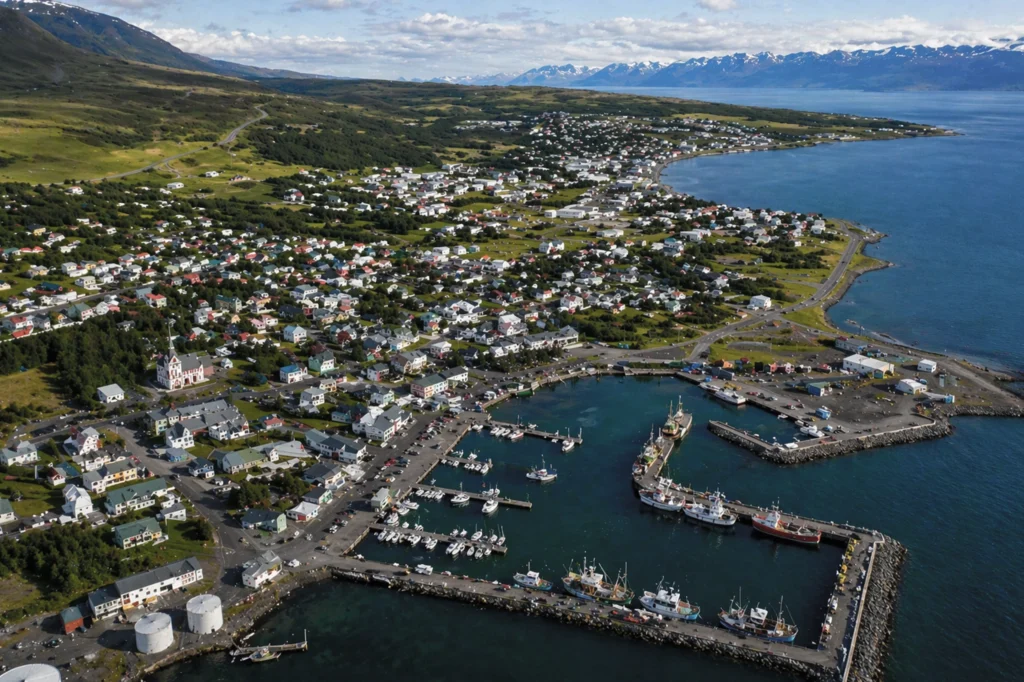 Vista aérea de Húsavík con puerto, casas y costa del norte de Islandia