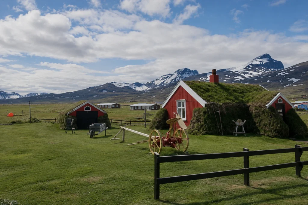 Casa tradicional islandesa con techo de césped en Borgarfjörður Eystri y montañas nevadas al fondo