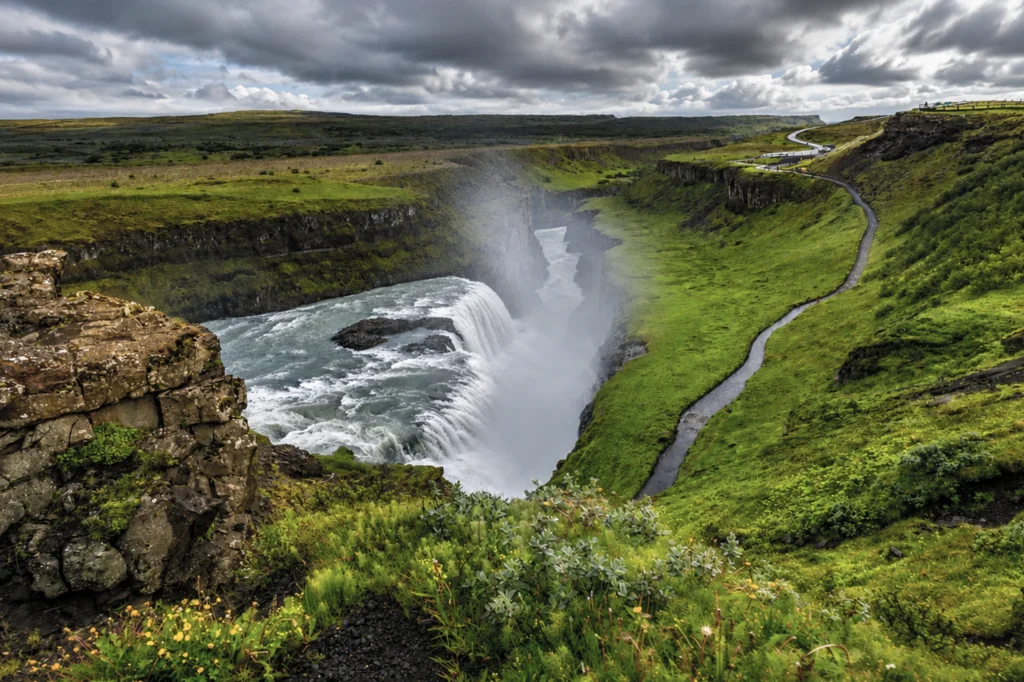 Cascada Gullfoss en Islandia con río glacial y cañón verde bajo cielo nublado