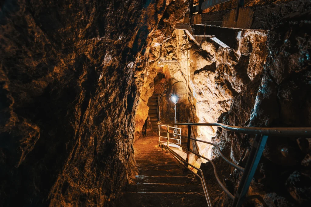 Escaleras en el interior de la cueva de lava Raufarhólshellir iluminadas con luz cálida en Islandia