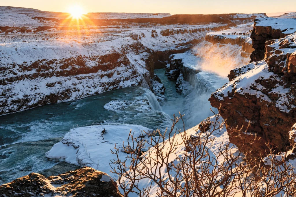 Cascada Gullfoss en invierno al atardecer con nieve y luz dorada en Islandia