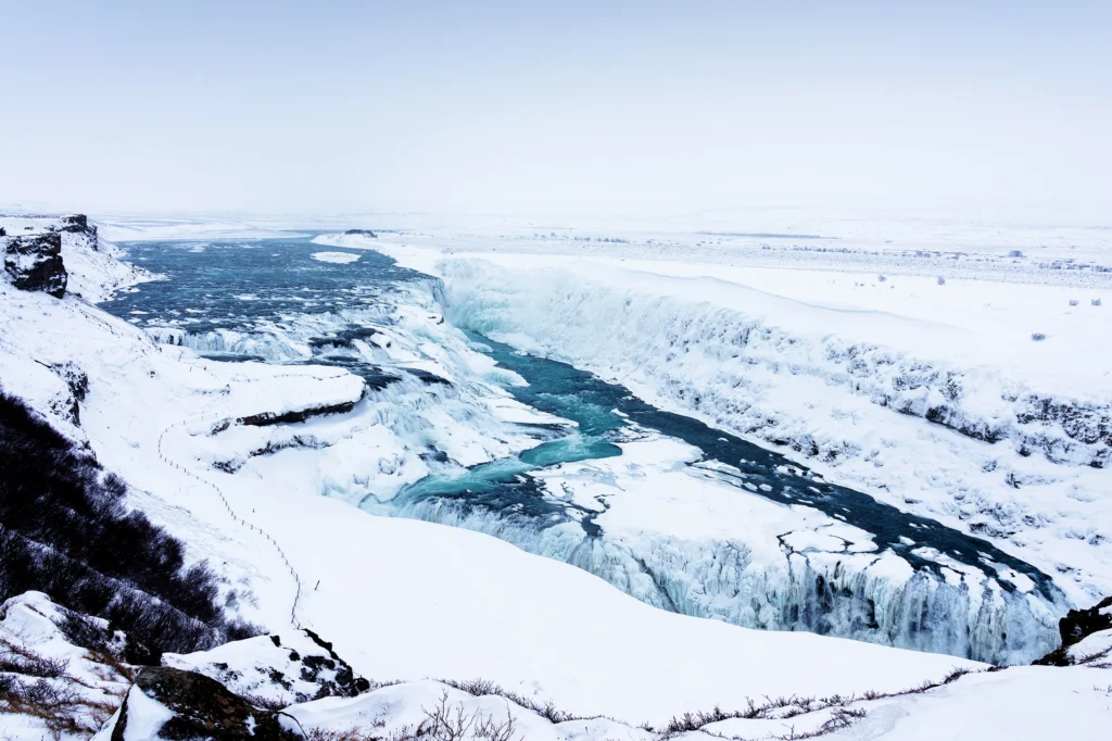Cascada Gullfoss en invierno congelada con río glacial entre nieve en Islandia
