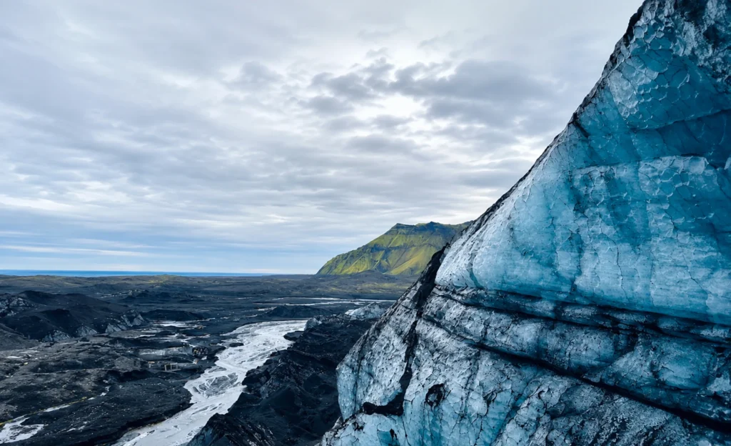 Detalle del glaciar Katla en Islandia con hielo azul y río glaciar en paisaje volcánico