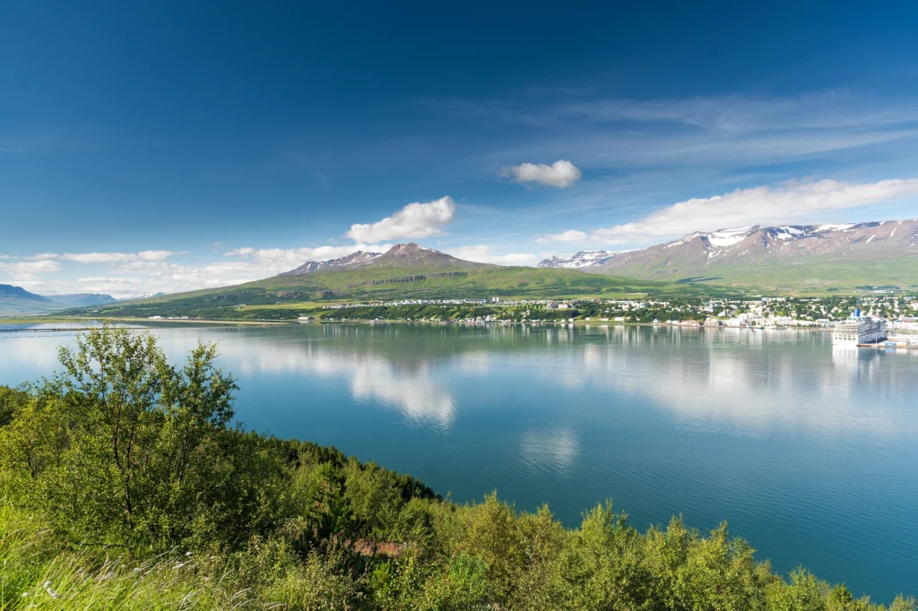 Vista panorámica de Akureyri con el fiordo Eyjafjörður, montañas y reflejo en el agua en Islandia