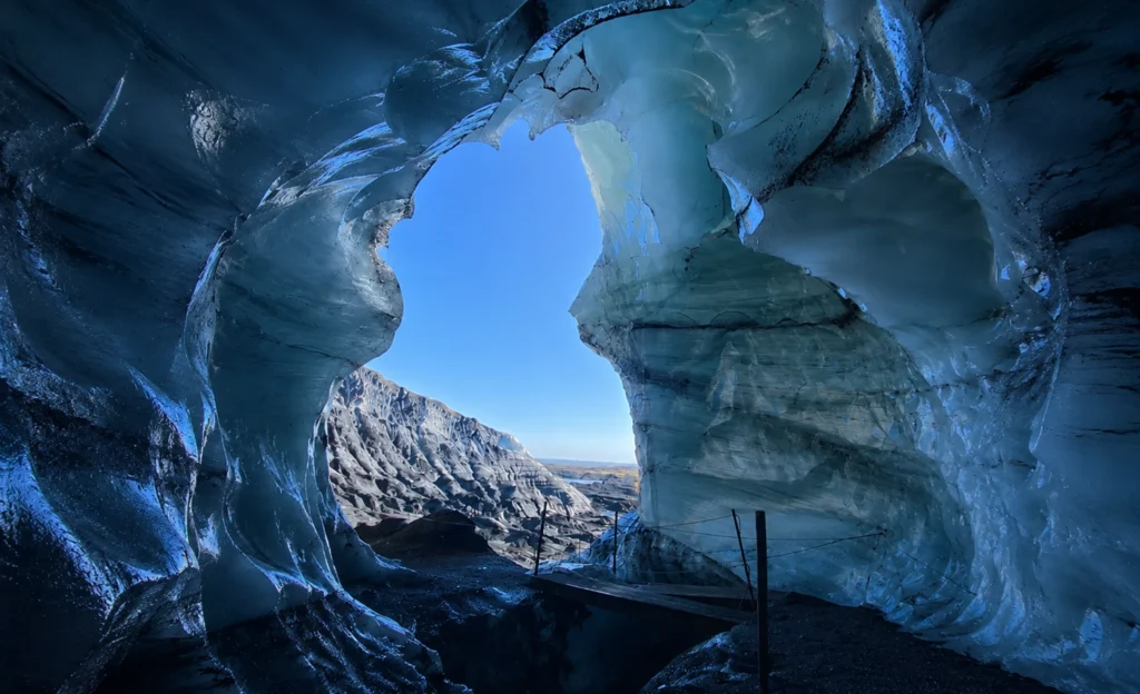 Interior de cueva de hielo azul en Katla con abertura hacia el glaciar en Islandia