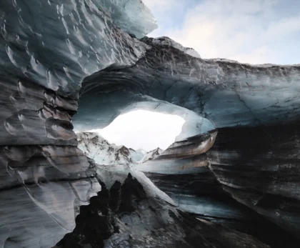 Cueva de hielo de Katla en Islandia con formaciones glaciales y apertura hacia montañas