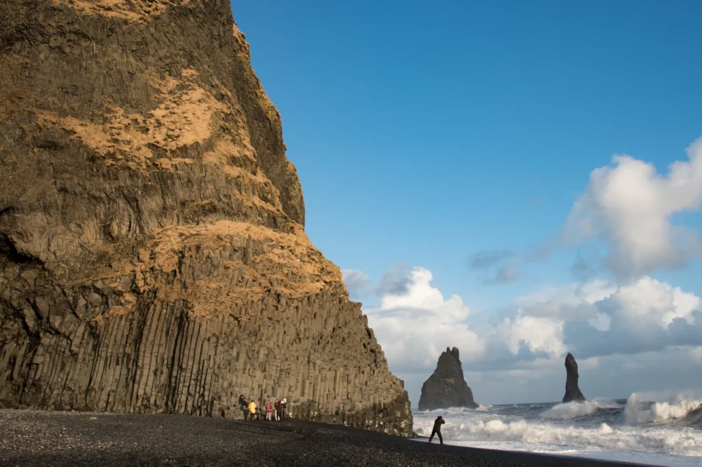 Columnas de basalto en la playa de Reynisfjara con los farallones Reynisdrangar y olas del Atlántico