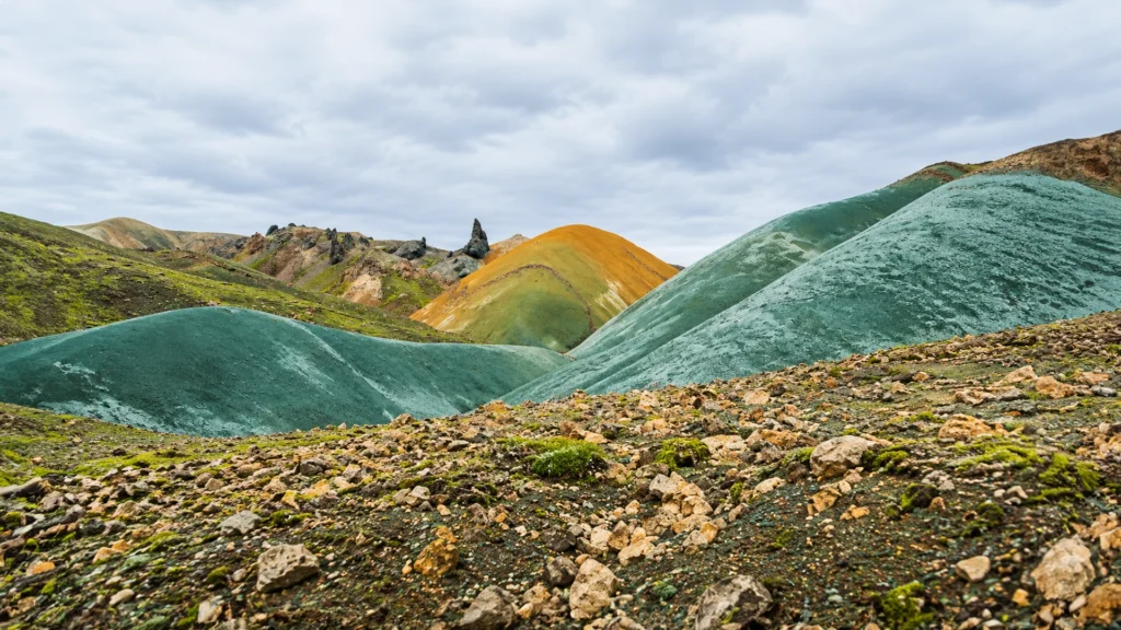 Colinas de tonos turquesas, verdes y ocres en el paisaje de Grænihryggur, Islandia.