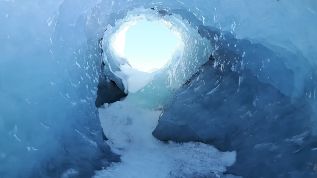 Interior de cueva de hielo en el glaciar Langjökull con luz natural al fondo