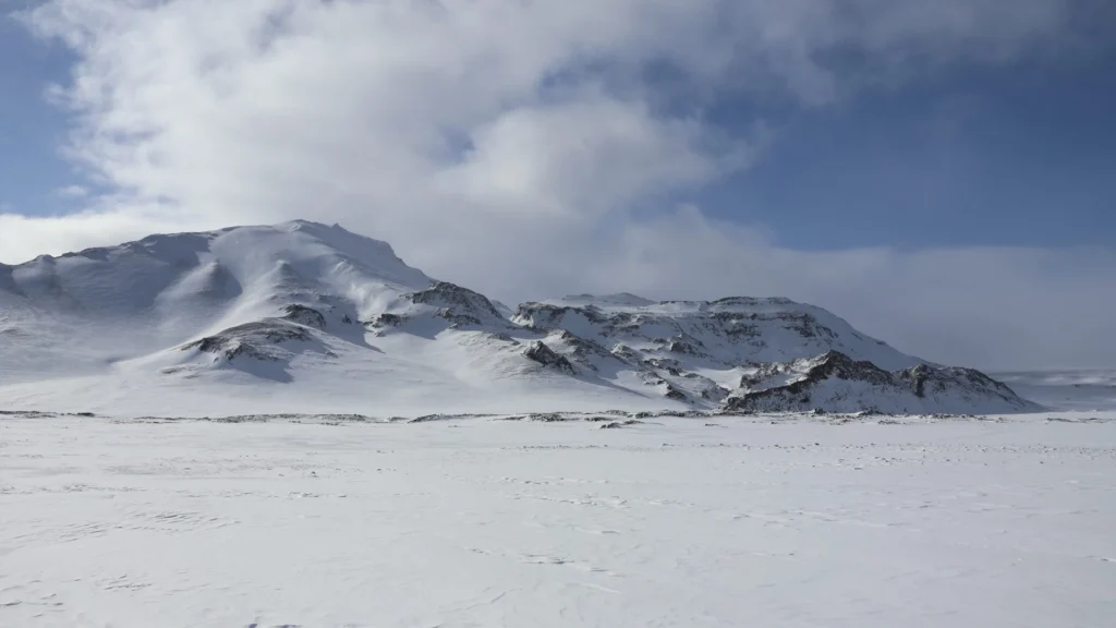 Montañas cubiertas de nieve en Islandia con paisaje invernal y cielo nublado