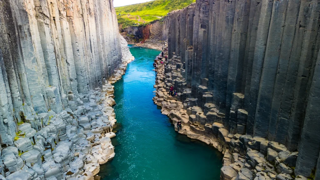 Cañón Stuðlagil con columnas de basalto y río azul turquesa en Islandia con visitantes
