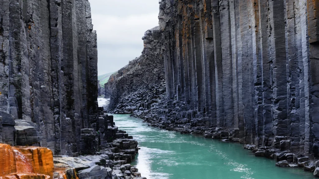 Columnas de basalto en el cañón Stuðlagil con río glaciar en Islandia