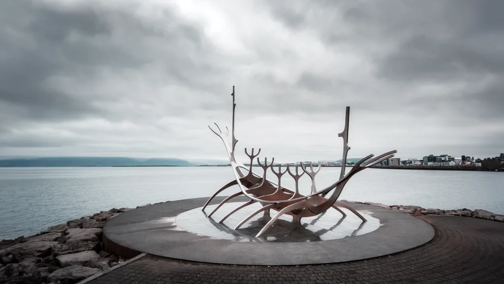 Escultura Viajero del Sol junto al mar en Reikiavik, Islandia, bajo un cielo gris y nublado.