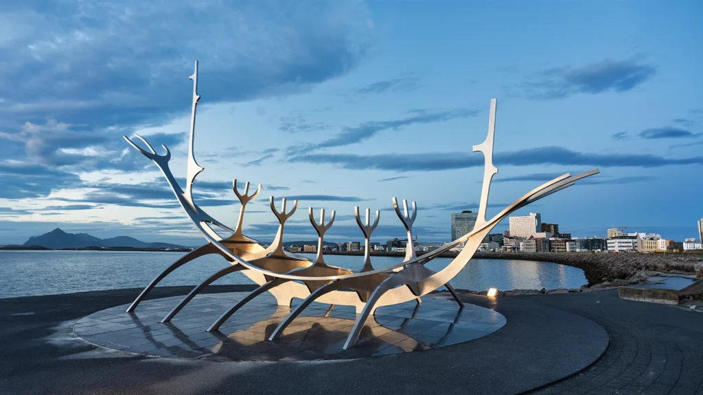Escultura Viajero del Sol junto al mar durante la hora azul en Reikiavik, Islandia.