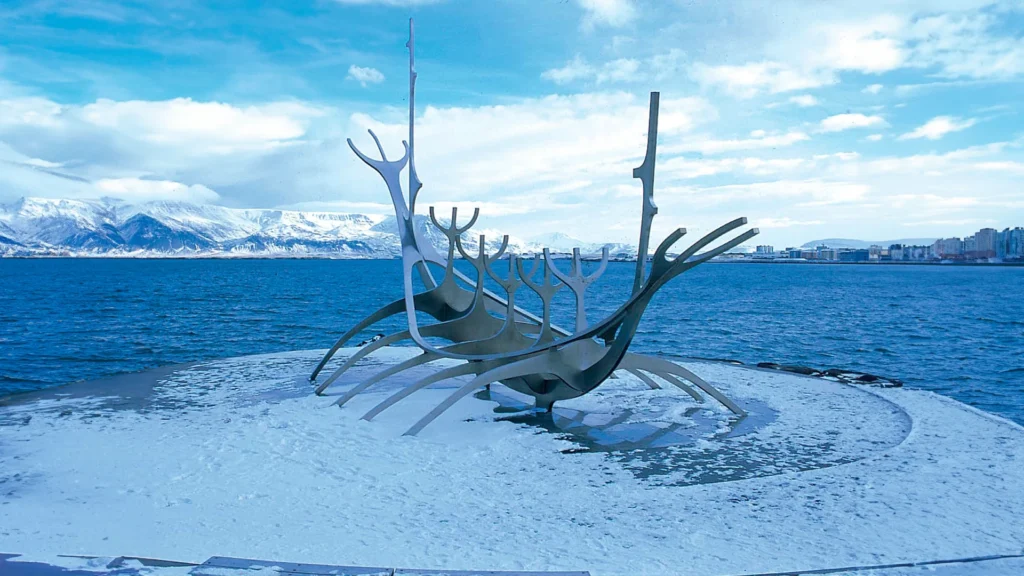 Escultura Viajero del Sol rodeada de nieve junto al mar en Reikiavik, Islandia.
