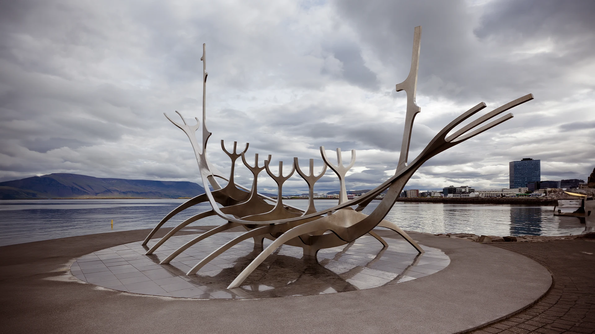 Escultura Viajero del Sol junto al mar en Reikiavik, Islandia, bajo un cielo nublado.