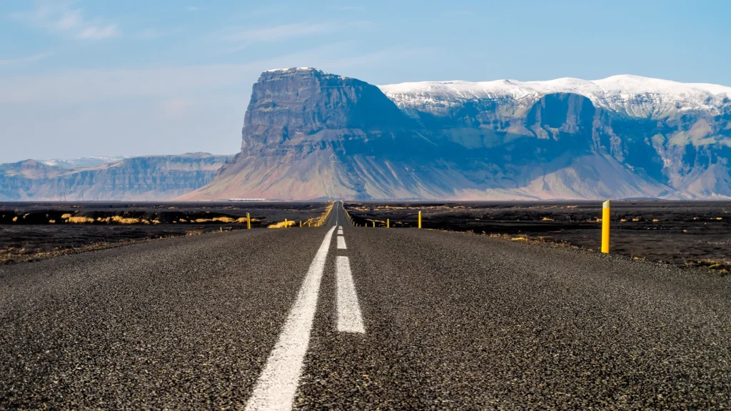 Carretera entre montañas nevadas durante un viaje por libre a Islandia