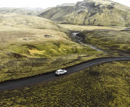 Coche 4x4 recorriendo una carretera de grava entre montañas de Islandia